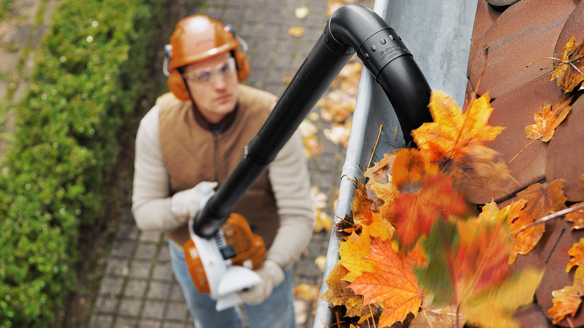 Homme avec souffleur thermique BG 56 de STIHL qui nettoie une gouttière