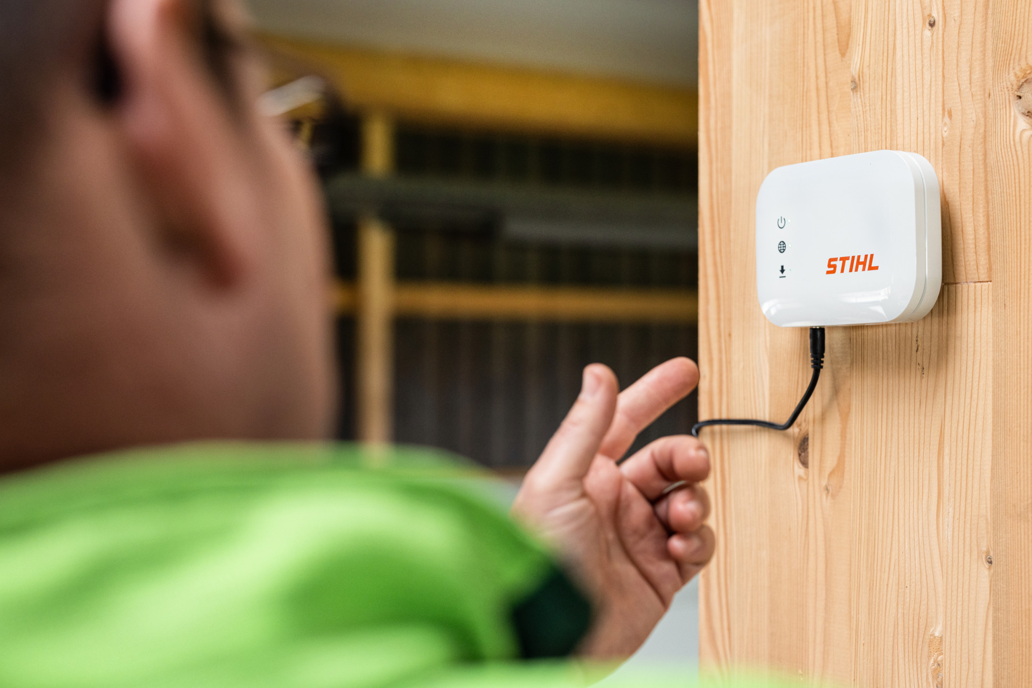 Gros plan sur une personne qui montre la STIHL connected mobile Box