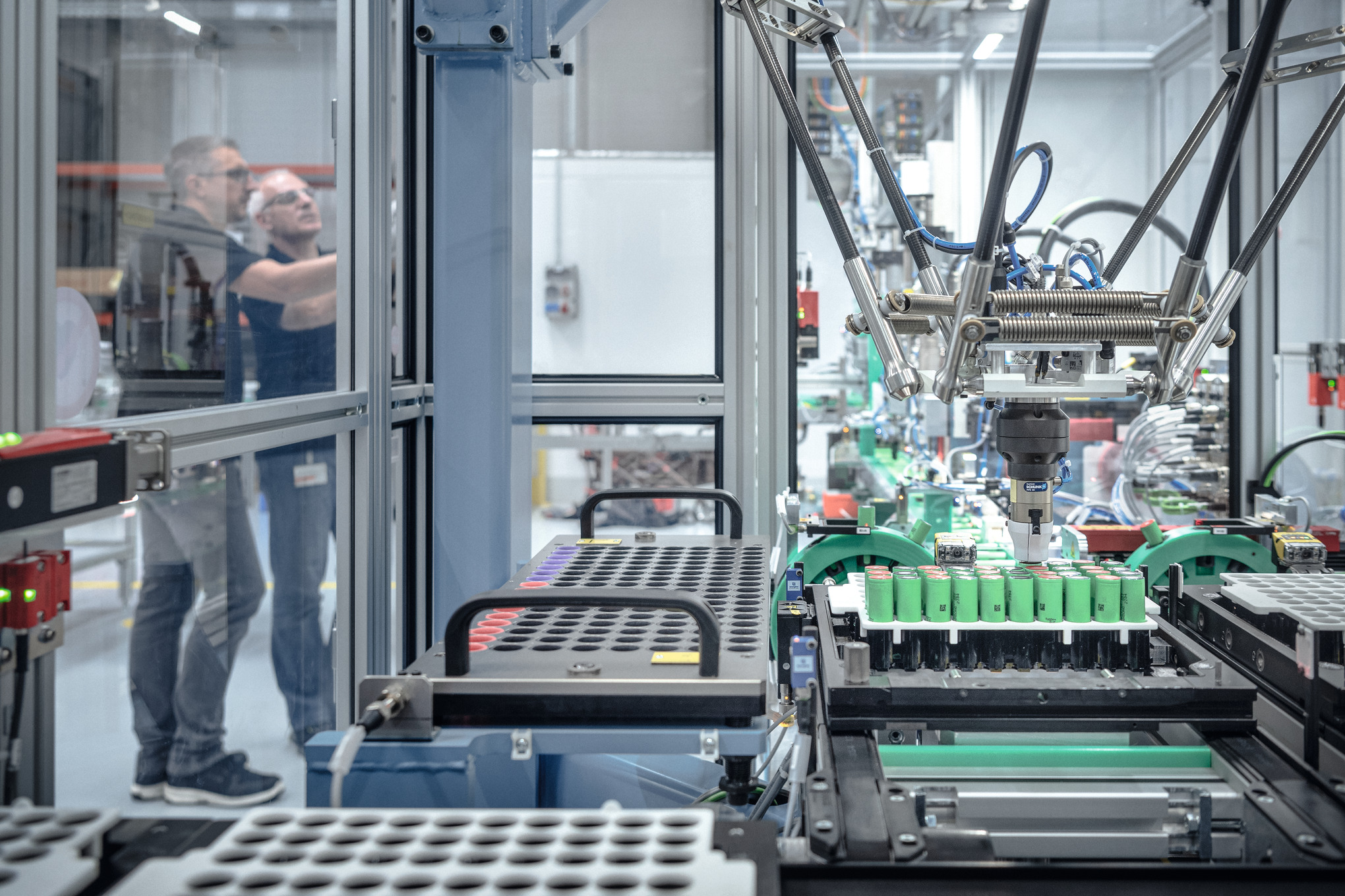 Deux hommes dans la fabrication de batteries STIHL entourés de machines et de robots
