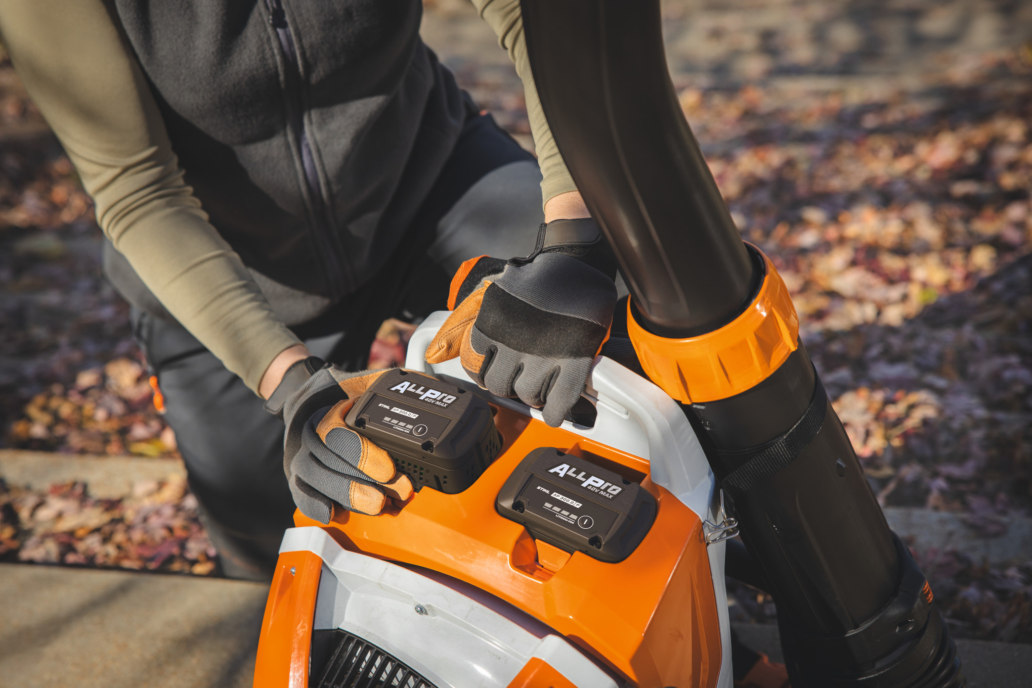 Un paysagiste professionnel installe la deuxième batterie STIHL AP 300.0 P dans le souffleur à dos sans fil STIHL.