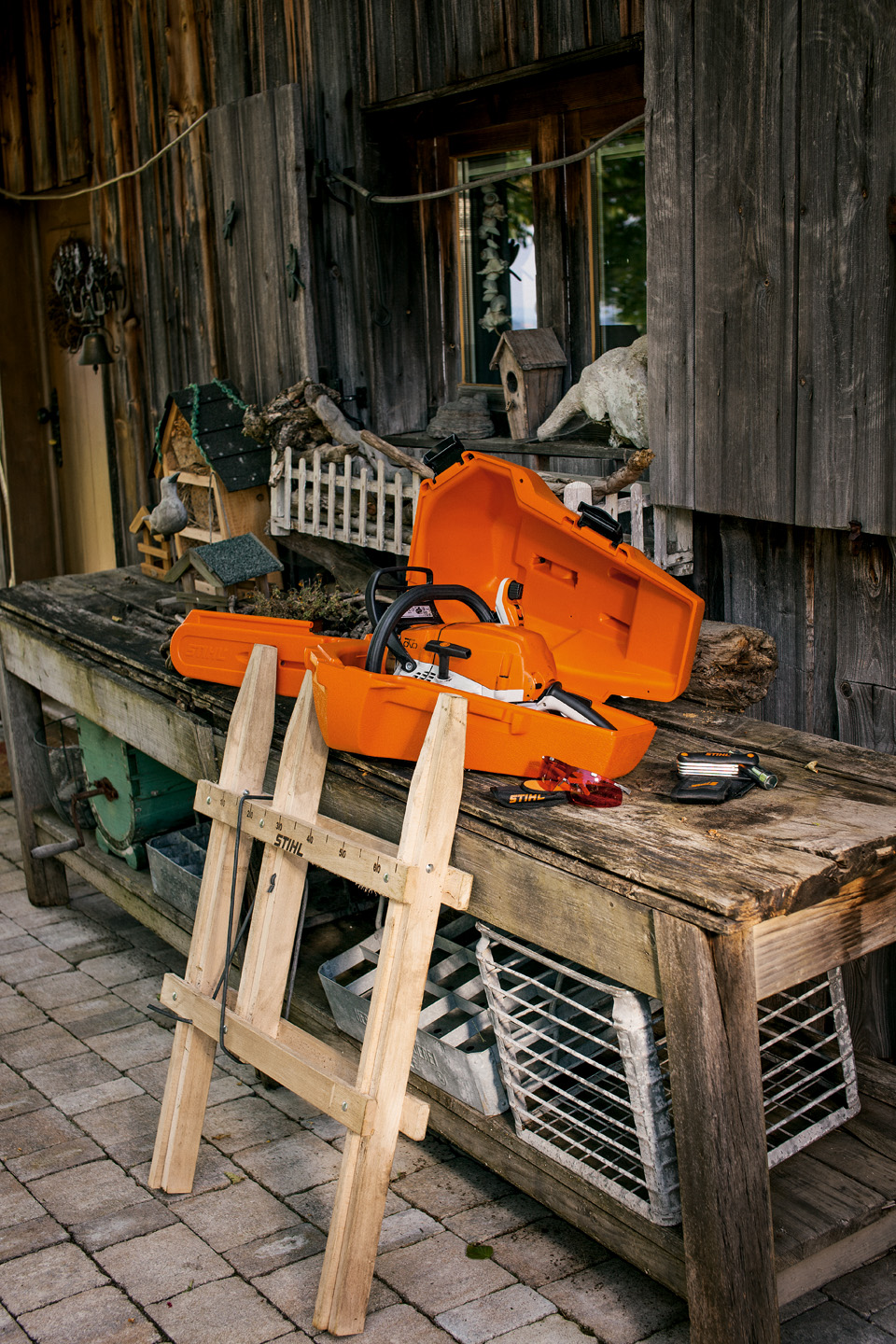 Une tronçonneuse STIHL dans un étui de stockage en plastique sur un établi en bois