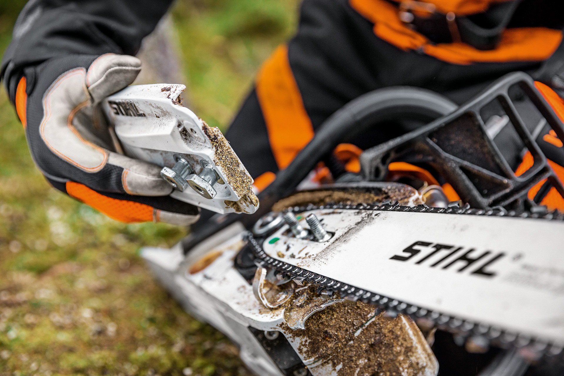 Gros plan sur le couvercle démonté du pignon de chaîne d’une tronçonneuse thermique STIHL MS 261 C-M