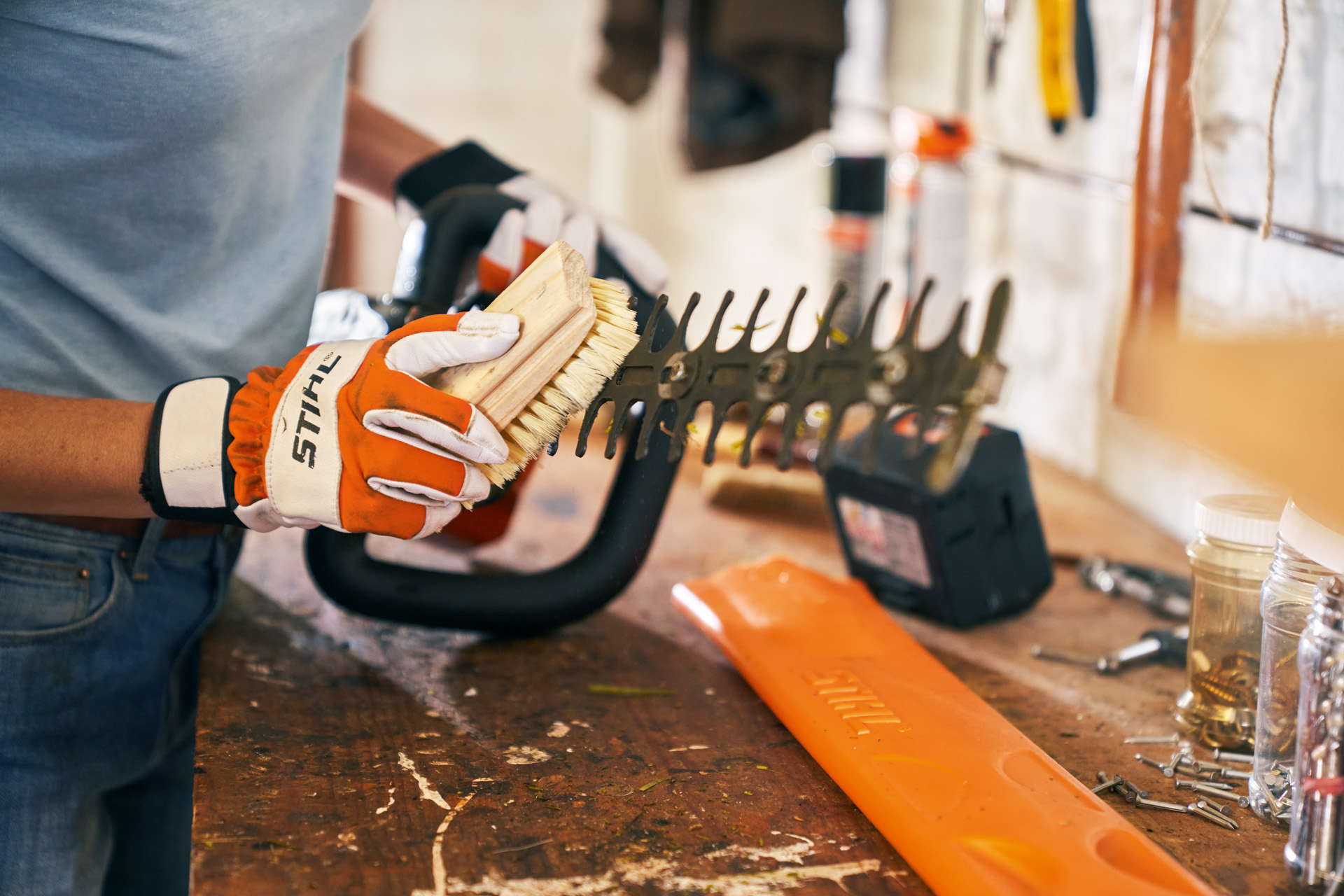 Entretien des taille-haies&nbsp;: Le taille-haie STIHL HSA&nbsp;56 fonctionnant sur batterie se nettoie avec une brosse