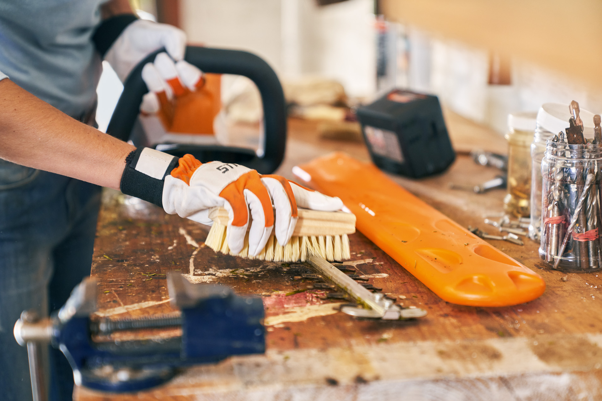 Nettoyage à la brosse d’un taille-haie sur batterie STIHL HSA 56, avec gants de protection