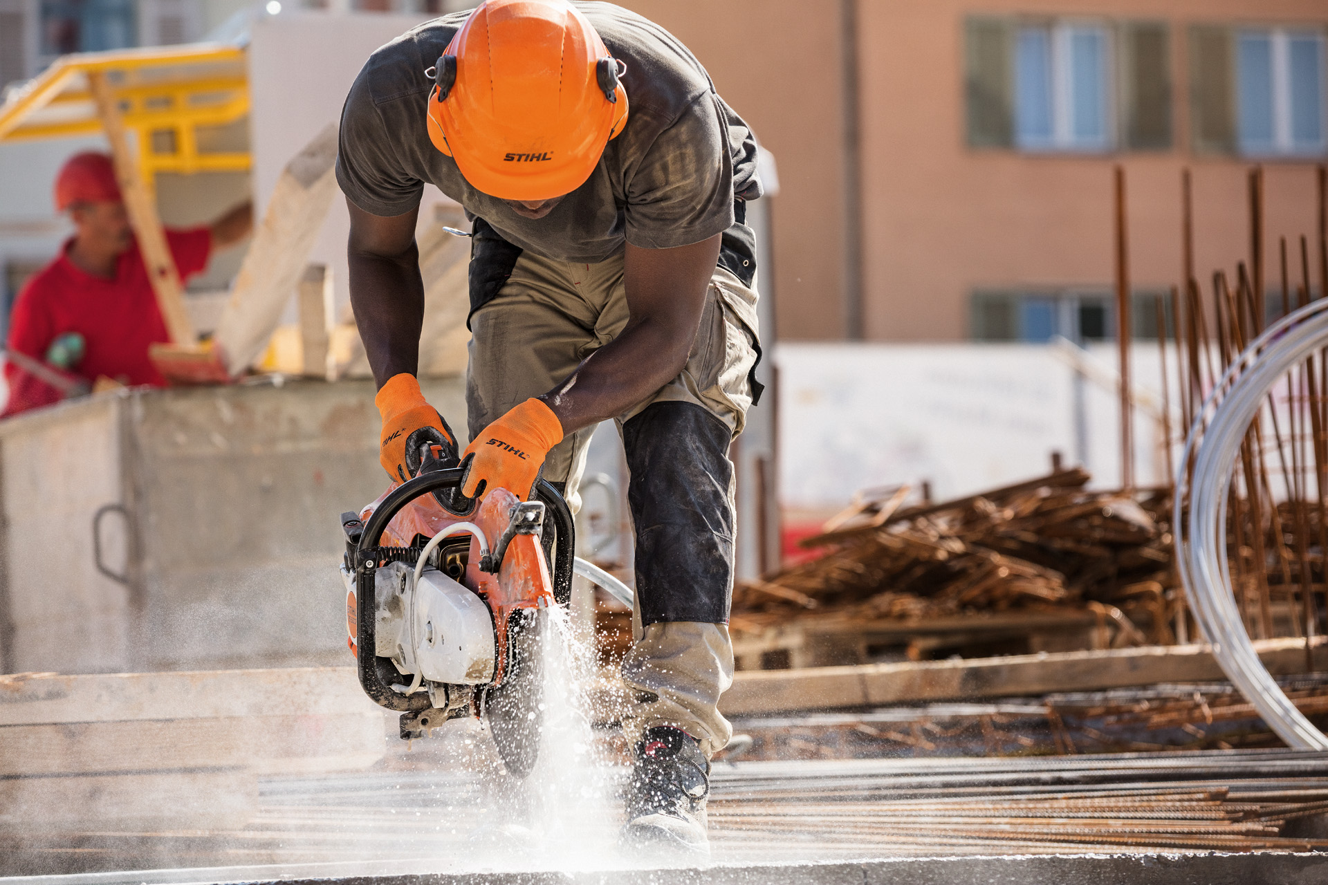 Un homme revêtant un équipement de protection et travaillant avec une tronçonneuse STIHL TS 500i sur un chantier de construction