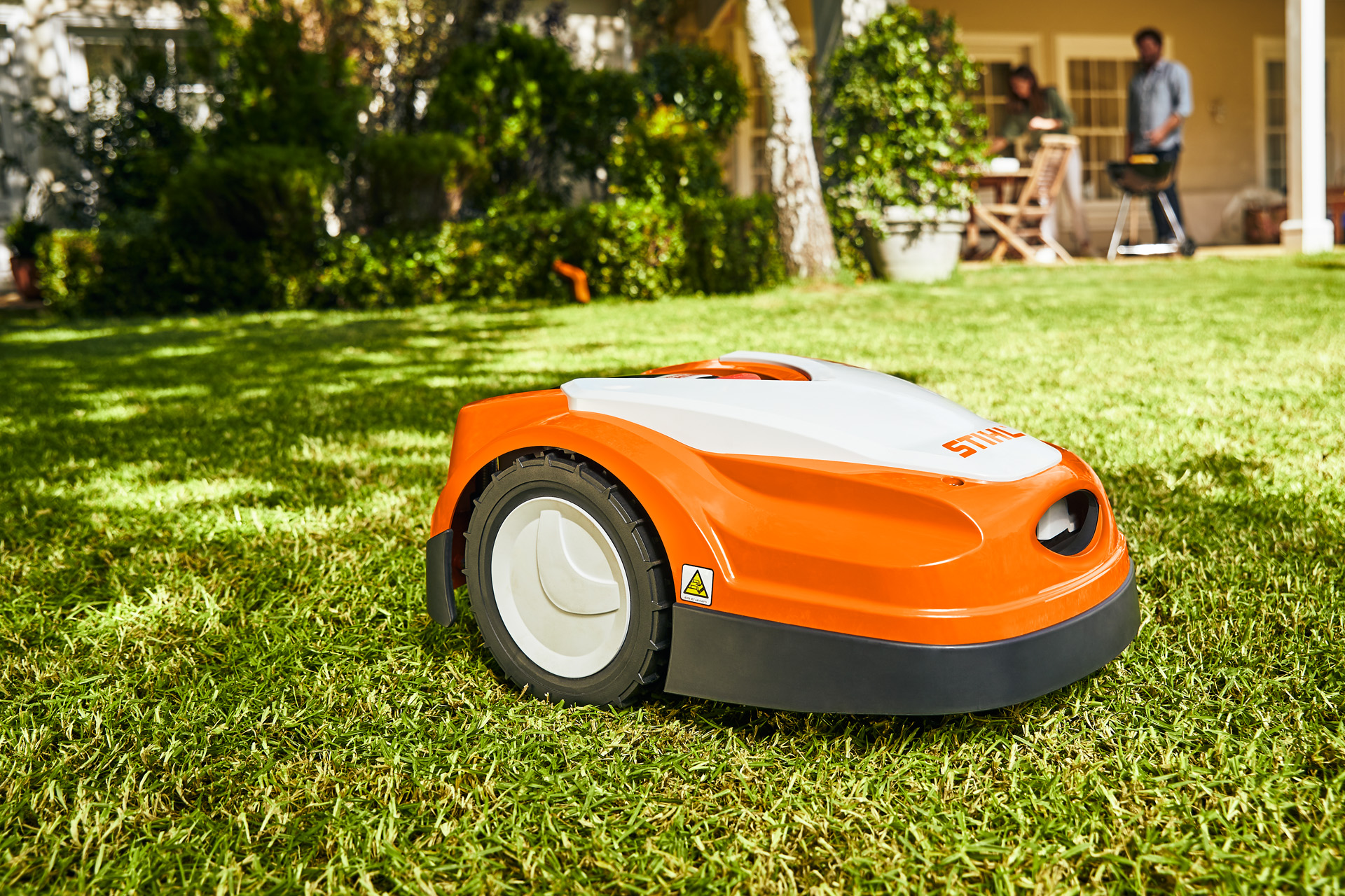 Robot tondeuse iMOW® RI 422 STIHL sur une pelouse devant une maison