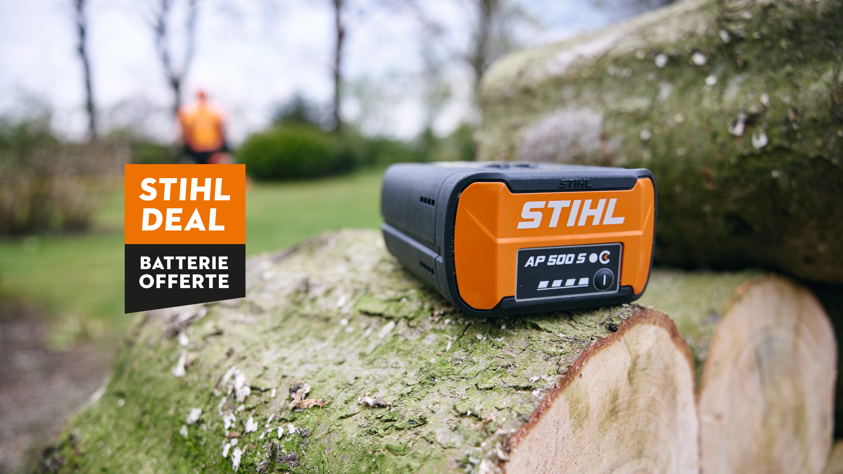 Batterie STIHL AP 500 S dans la benne d’un pick-up avec la nouvelle tronçonneuse à batterie STIHL MSA 300, avec une affiche d’une batterie STIHL portant l’inscription « Get a free battery ».