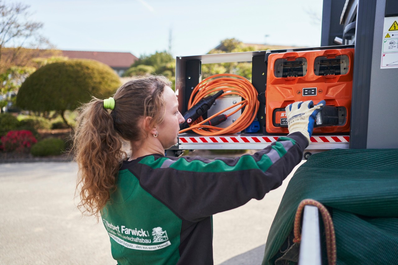 Collaboratrice de la société Farwick GmbH insérant des batteries dans un bottTainer sur un véhicule d’intervention