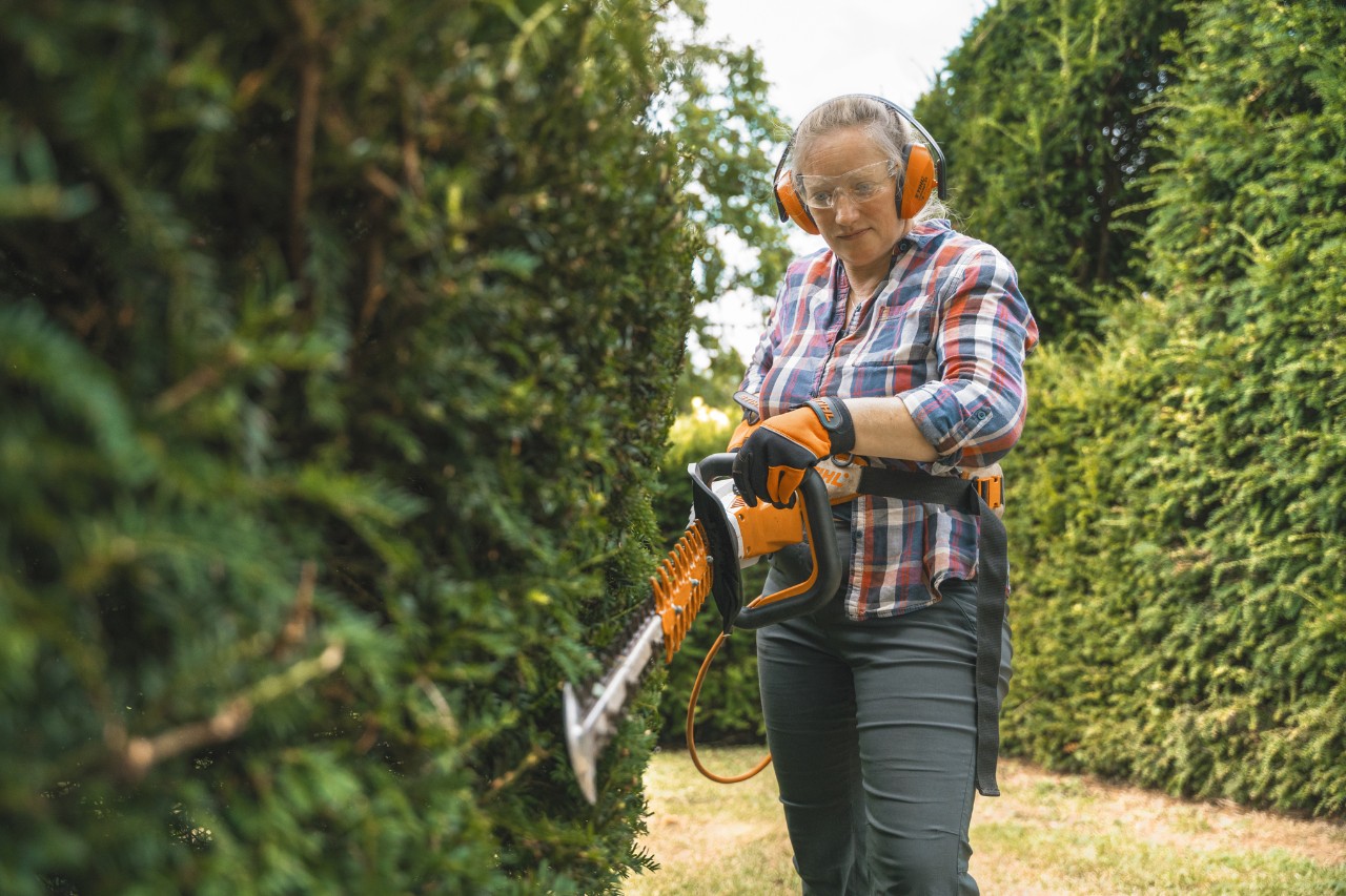 La cheffe jardinière Aldetha Raymond taille une haie avec un taille-haie à batterie STIHL HSA 130