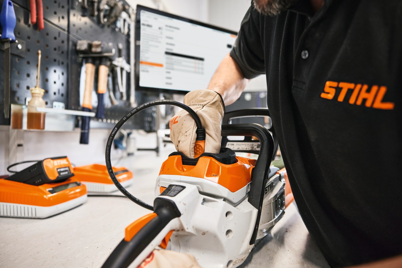 Un employé STIHL ou un revendeur spécialisé répare une tronçonneuse