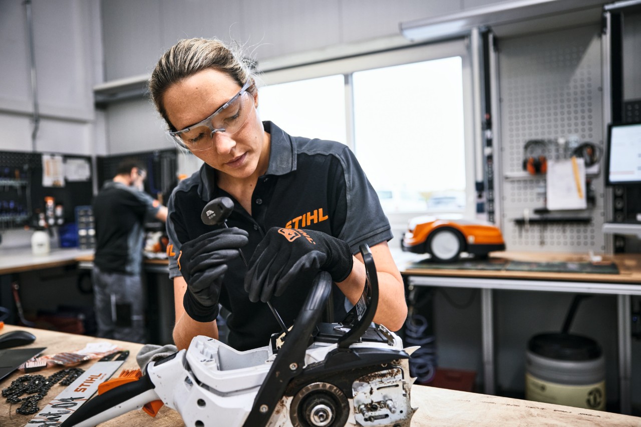 Un employé de STIHL ou d'un revendeur spécialisé répare une tronçonneuse