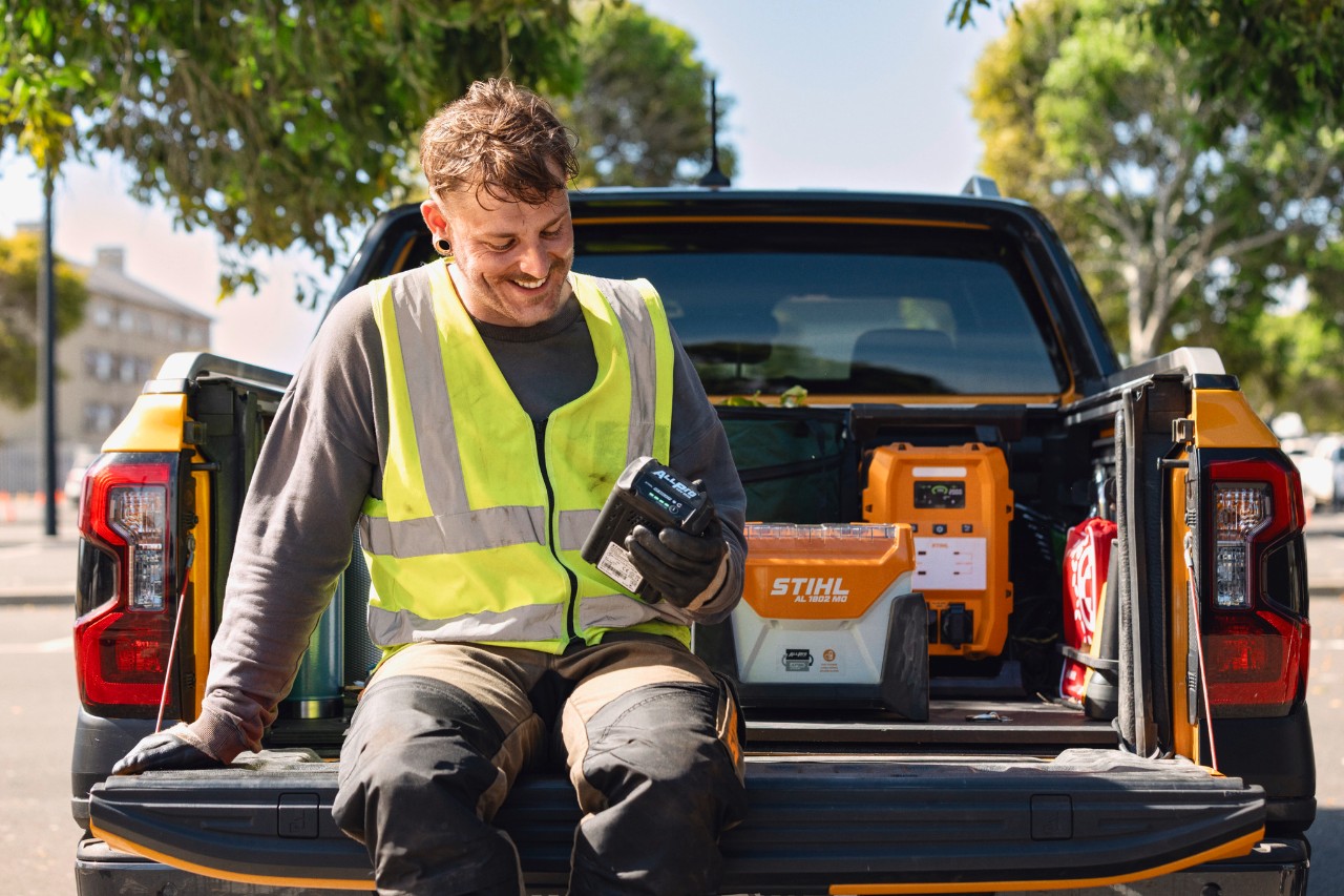 Un travailleur tenant une batterie ALLPRO sur un camion