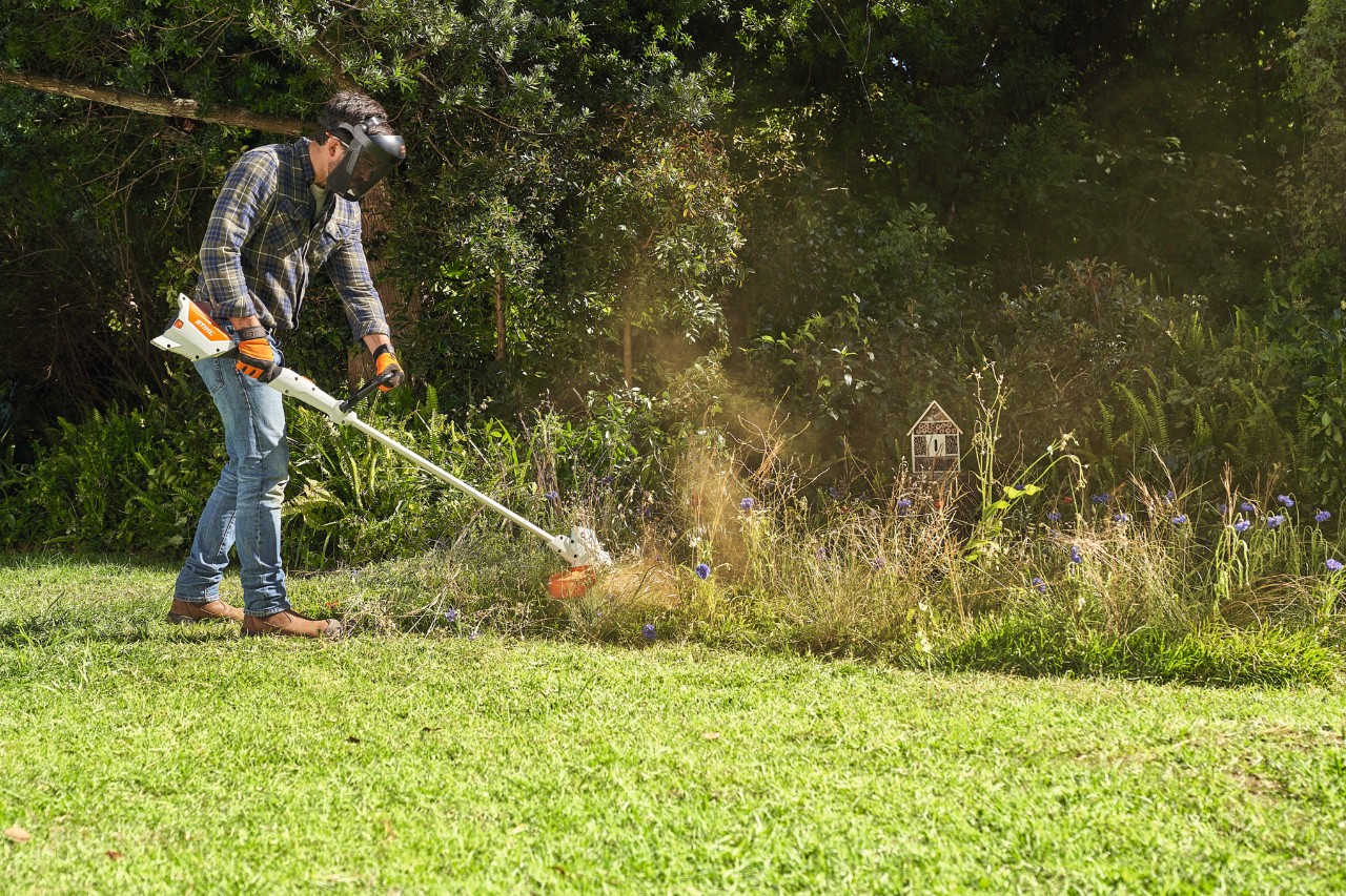 Homme débroussaillant une prairie de fleurs sauvages avec le STIHL FSA 57
